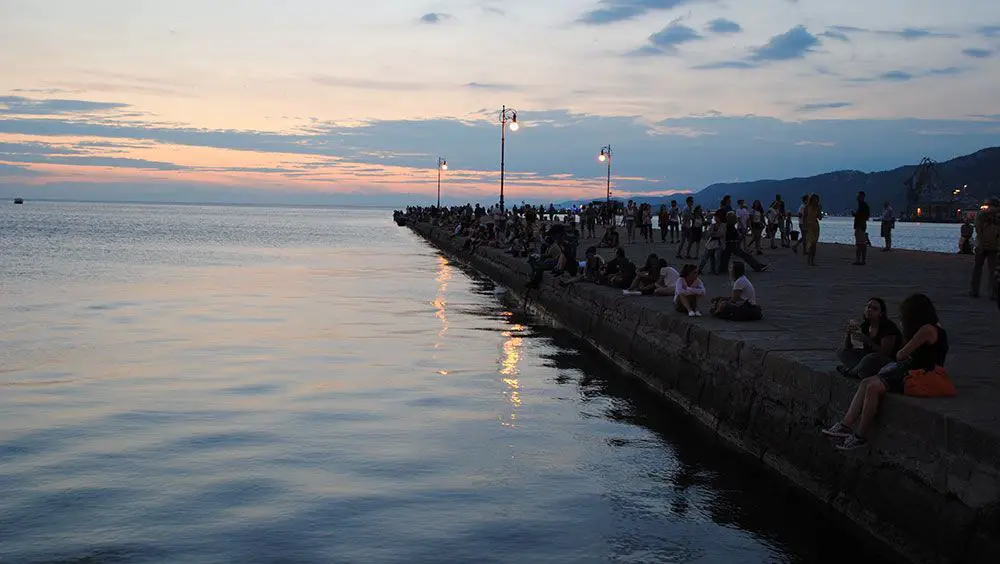 Empieza tu viaje en Trieste 3 Turistas mirando hacia el Adriático