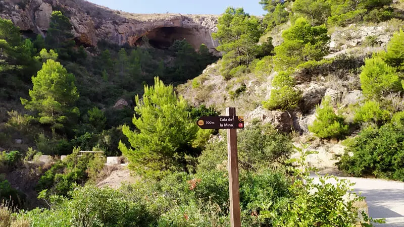 Excursión al Faro del Albir y sus calas 5 Indicación para seguir el camino a la cala de la Mina, con la cueva de la ballena al fondo